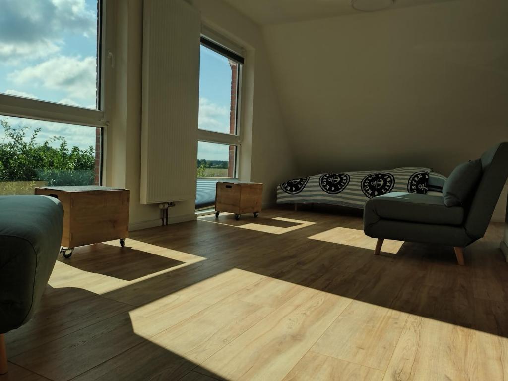 sala de estar con cama, sofá y ventanas en Finca Franca, en Klein Wittensee