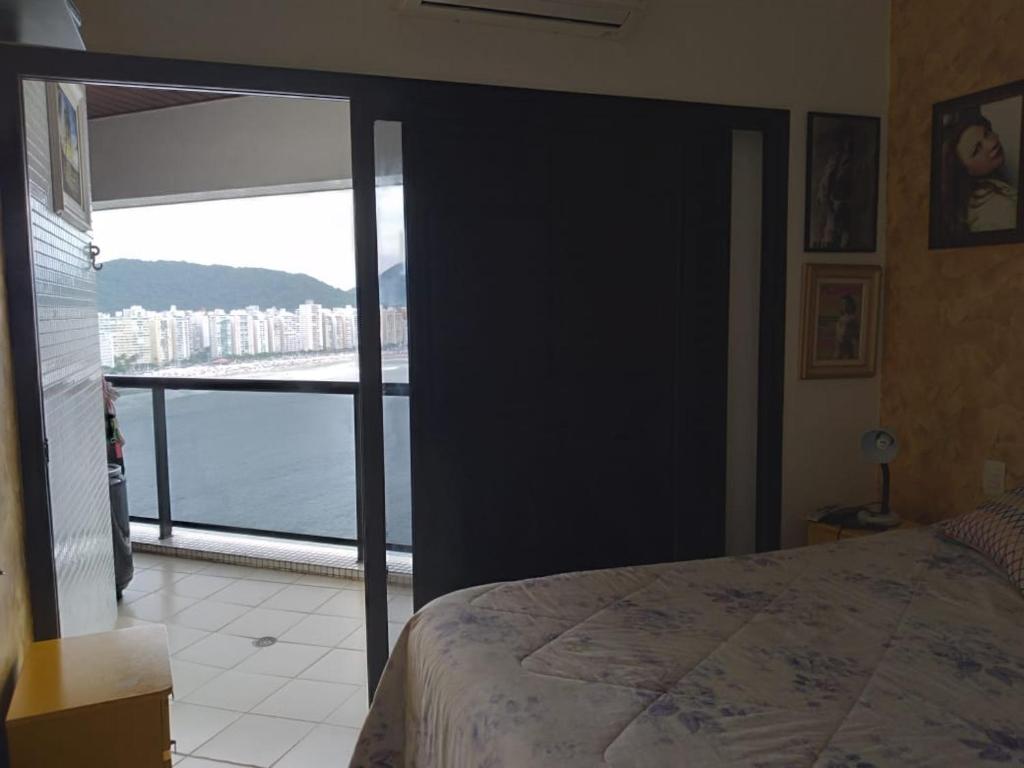 a bedroom with a bed and a view of the water at Espaço SOSSEGO in Guarujá