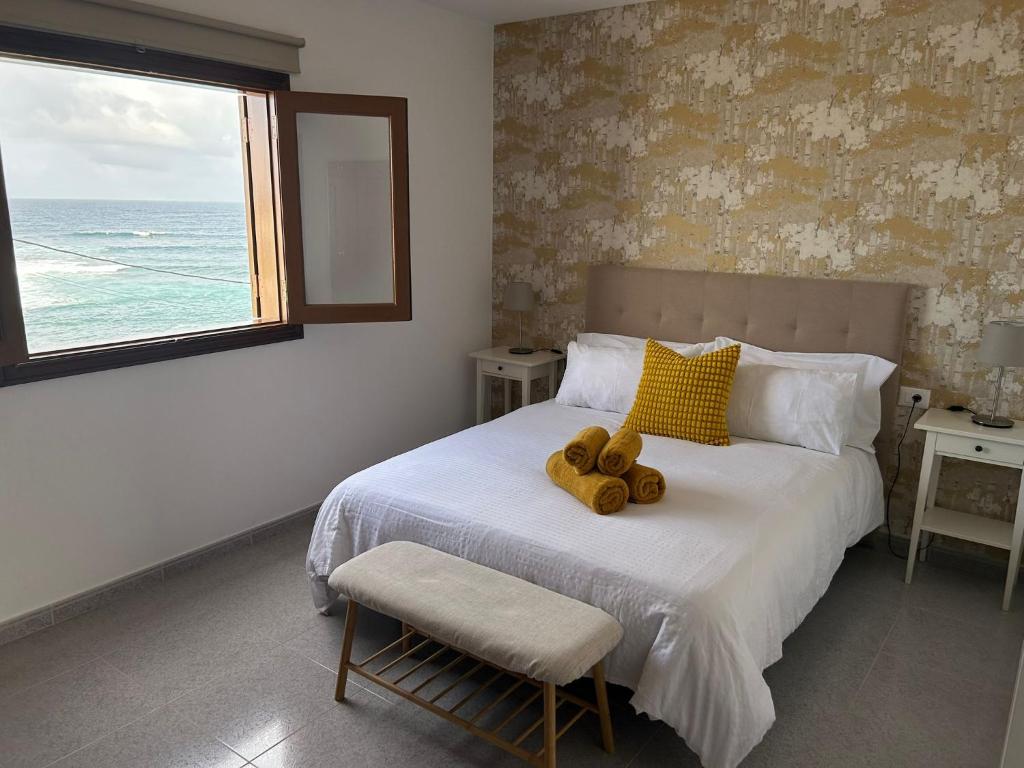 Un dormitorio con una cama con dos ositos de peluche encima. en Casa Ole, en Caleta de Caballo