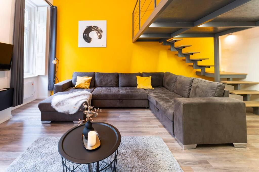 a living room with a couch and a staircase at Bolero2 apartman in Budapest