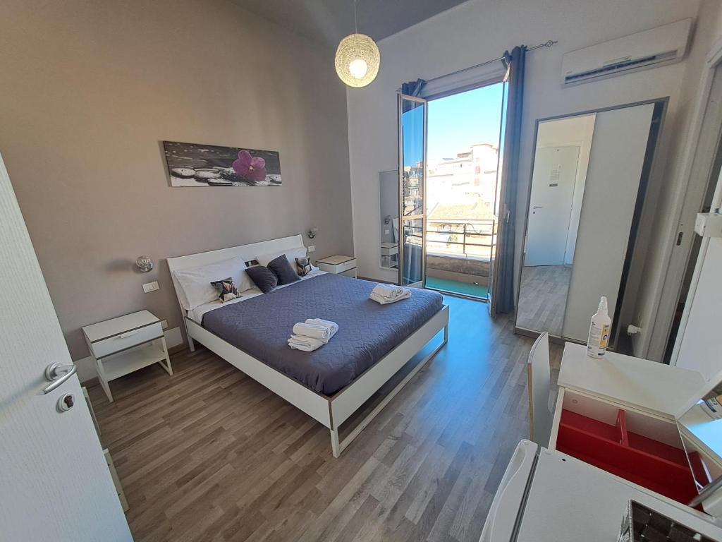 een slaapkamer met een bed en een groot raam bij Bedroom la stazione in Palermo