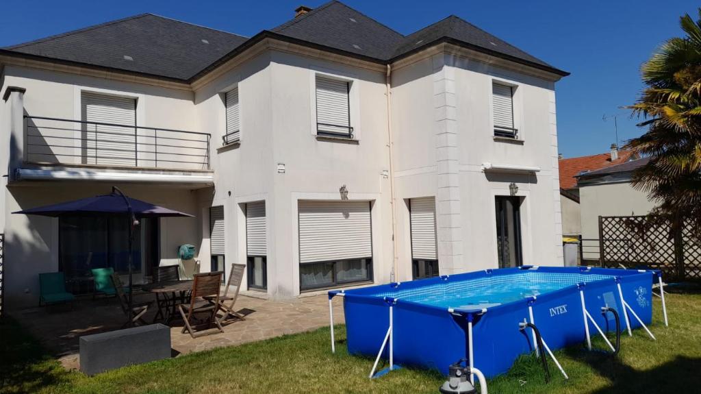 a house with a blue pool in the yard at Villa d'architecte 4 chambres 9 Personnes Proche Disney Paris in Le Perreux-Sur-Marne