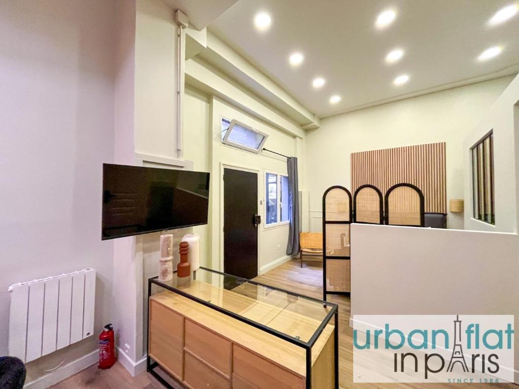 un salon avec une table en verre et une télévision dans l'établissement Urban Flat 05 - Beautiful Flat in Paris, à Paris