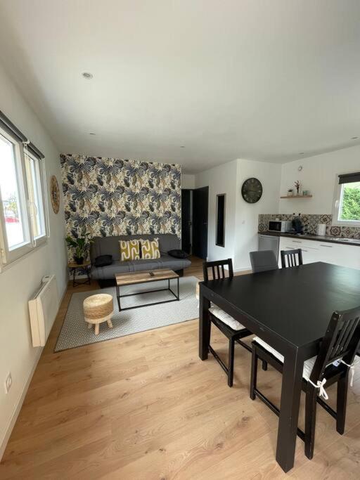 a living room with a black table and a couch at Les Chalets du Mancel Chalet Maïka -Bouleries Jump - 24h du Mans in Parence