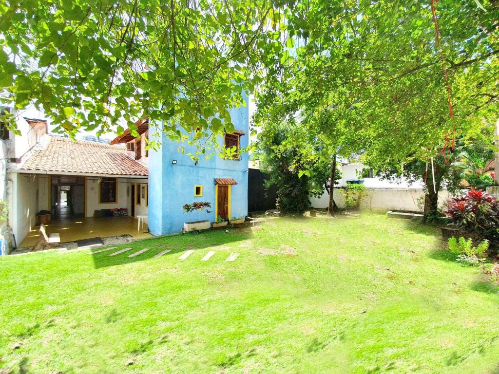 a blue house with a yard in front of it at Casa Guio in Salvador