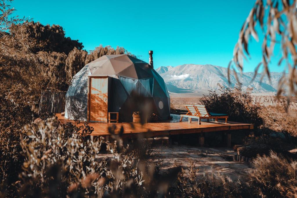 a yurt with a bench on a wooden deck at Domos Uspallata in Uspallata