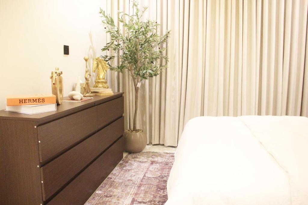 リヤドにあるرايا 03 raya القماريのベッドルーム1室(ベッド1台、植物付きドレッサー付)