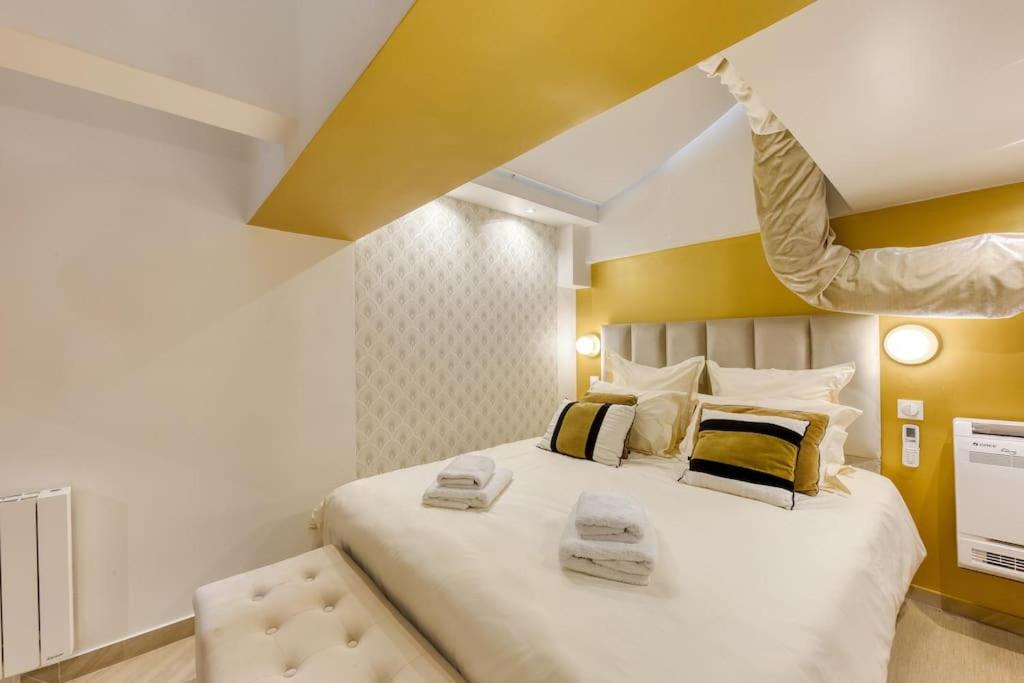 une chambre avec un grand lit avec deux serviettes dessus dans l'établissement Élysée Prestige, à Paris