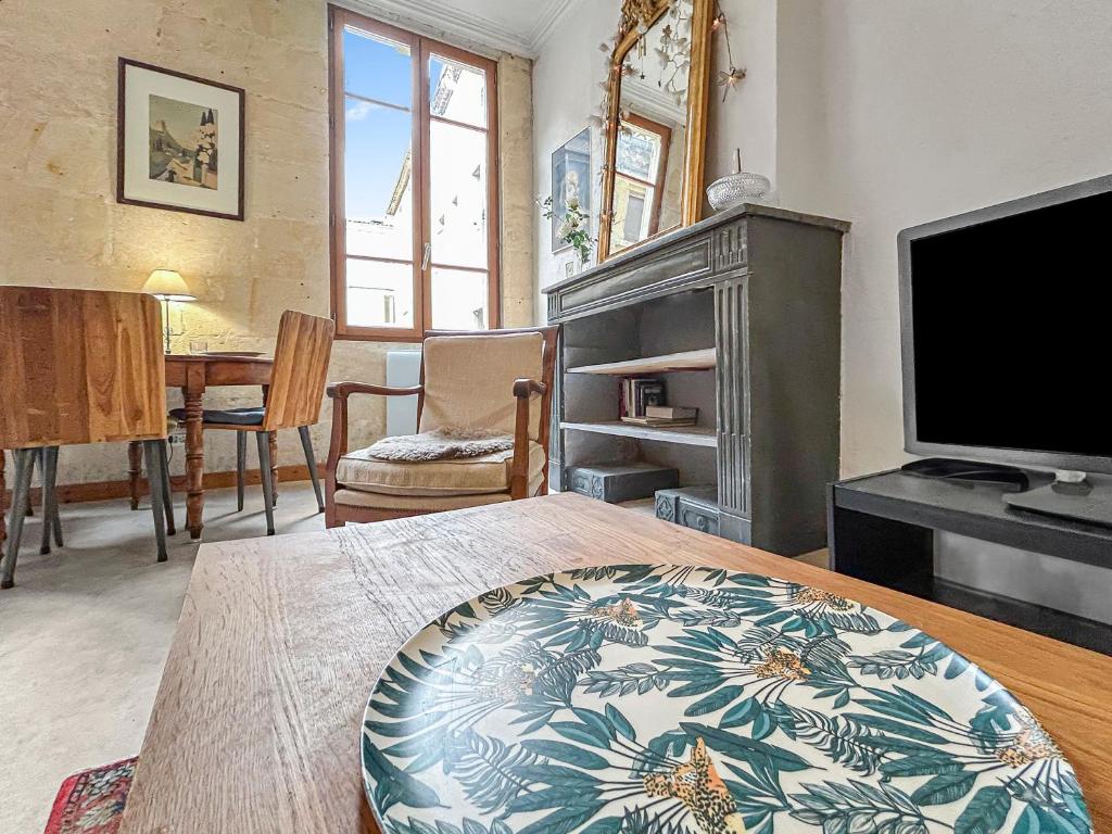 un salon avec un lit et une télévision dans l'établissement Évasion chic près des Arènes de Nîmes, à Nîmes