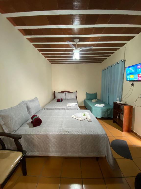 a bedroom with a large bed and a tv at Suítes Cosfer in Saquarema