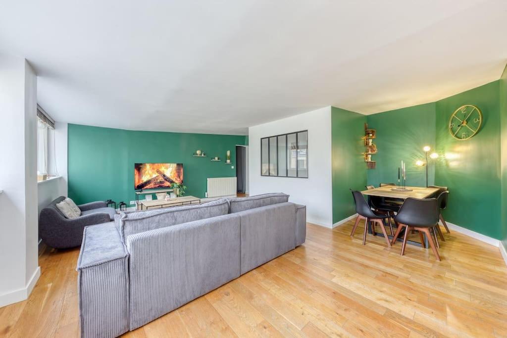 - un salon avec un grand canapé et une table dans l'établissement Le Spacieux Paris La défense, à Rueil-Malmaison