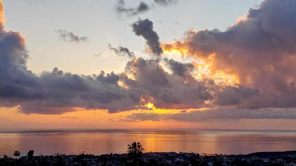 een zonsondergang over het water met wolken bij Ocean Views Beach House - 40 PCT Off Monthly in San Clemente