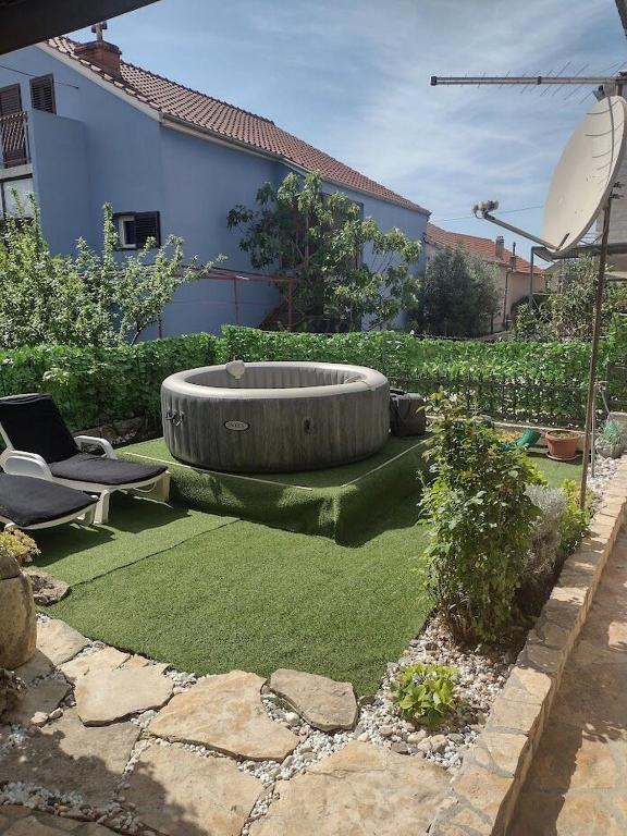 a garden with a large circle in the grass at Apartment AMare in Šibenik