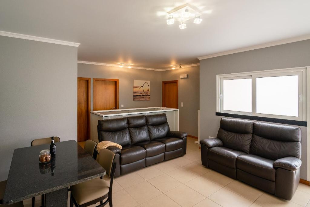 a living room with a couch and a table at Green Doors - AC and free parking in Machico