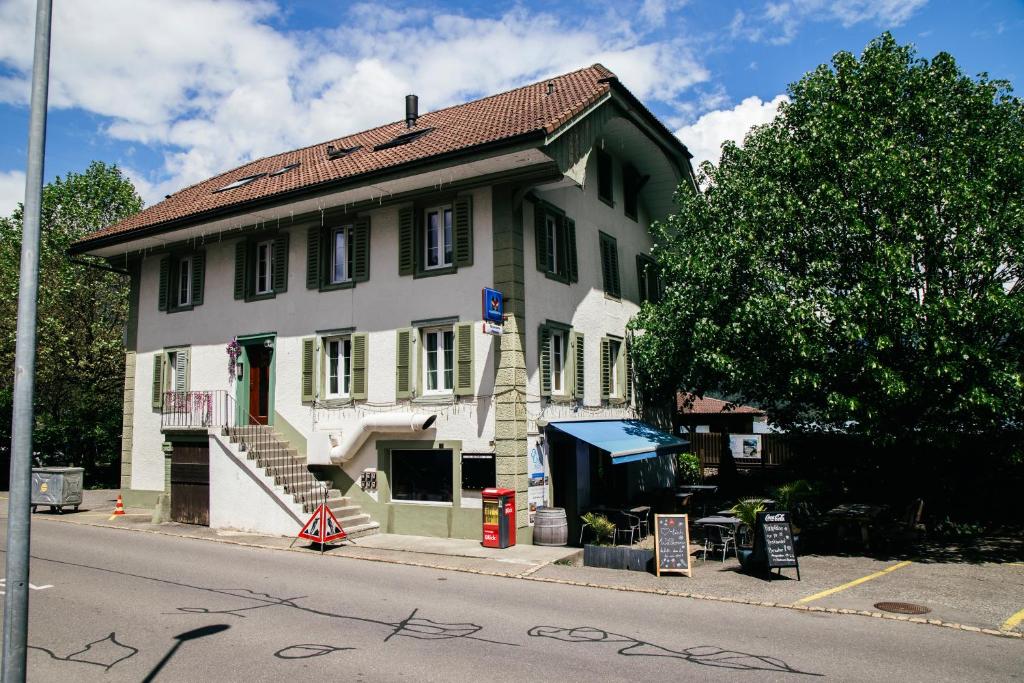 Ein weißes Haus an der Seite einer Straße in der Unterkunft Au Bord Du Lac in Därligen