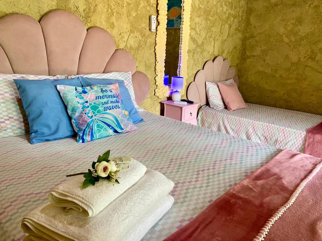 a bedroom with a bed with two towels on it at Gruta da Sereia Suítes Ubatuba in Ubatuba