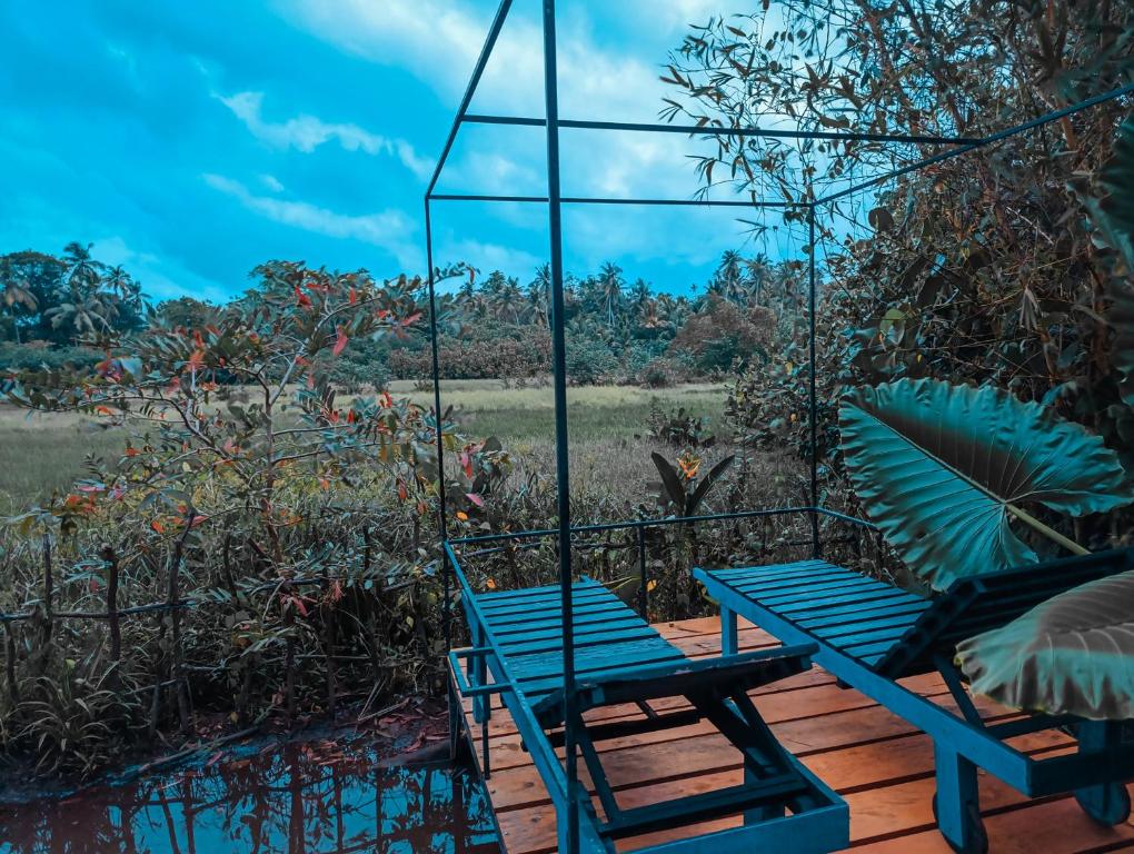 due sedie blu e un tavolo su una terrazza di The WE2 - Wildwood Elegance Escape a Bentota