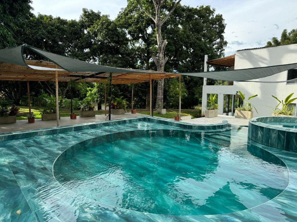 una piscina con agua azul en una casa en Villa San Martín, en Sopetrán