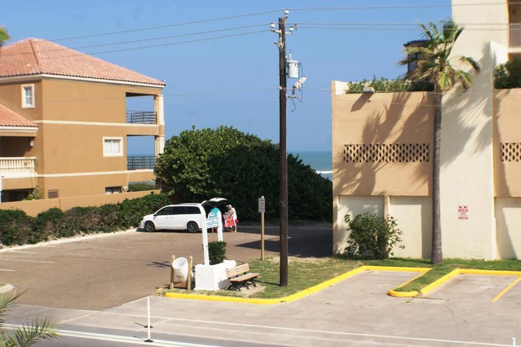 un coche blanco aparcado en un aparcamiento al lado de un edificio en Coronado 101 next to beach access, Pool, en South Padre Island
