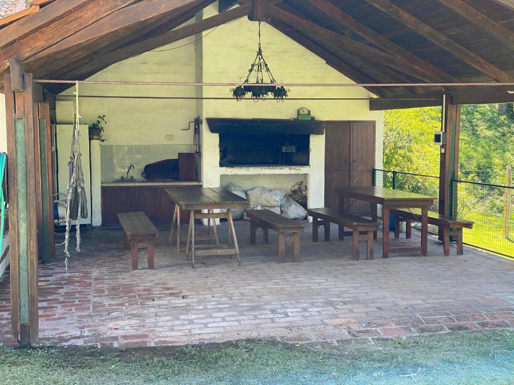a patio with a table and benches and a fireplace at El encuentro in Unquillo