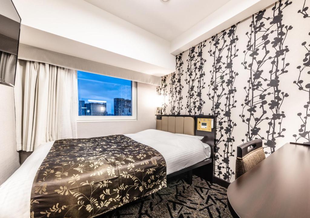 Postel nebo postele na pokoji v ubytování APA Hotel Higashi Shinjuku Kabukicho Tower