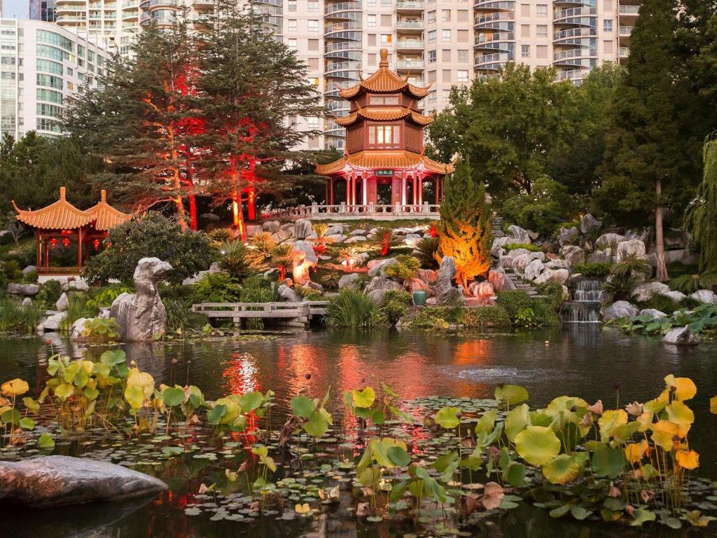 a garden with a pond and a pagoda in a city at Harbour Views, Fireworks & Secure Parking in Sydney