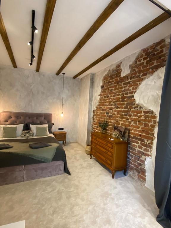 Un dormitorio con una cama y una pared de ladrillo. en Courthouse Apartments Slavi, en Sofía