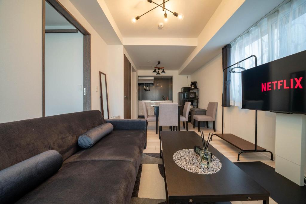 a living room with a couch and a television at MOXIE in Sapporo