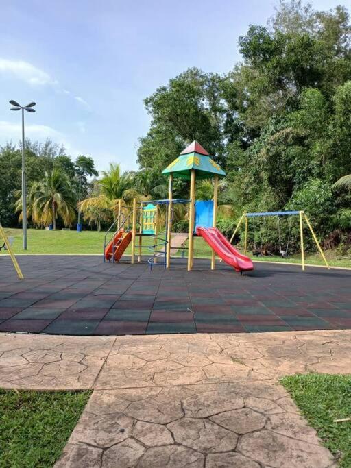 a playground with a slide and swings in a park at Homestay Bandar Kajang in Kajang