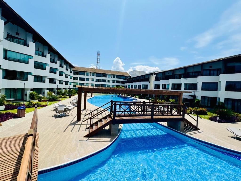 un puente sobre una piscina frente a un edificio en Flat no Maui - Beira-mar - Tamandaré - Carneiros, en Tamandaré