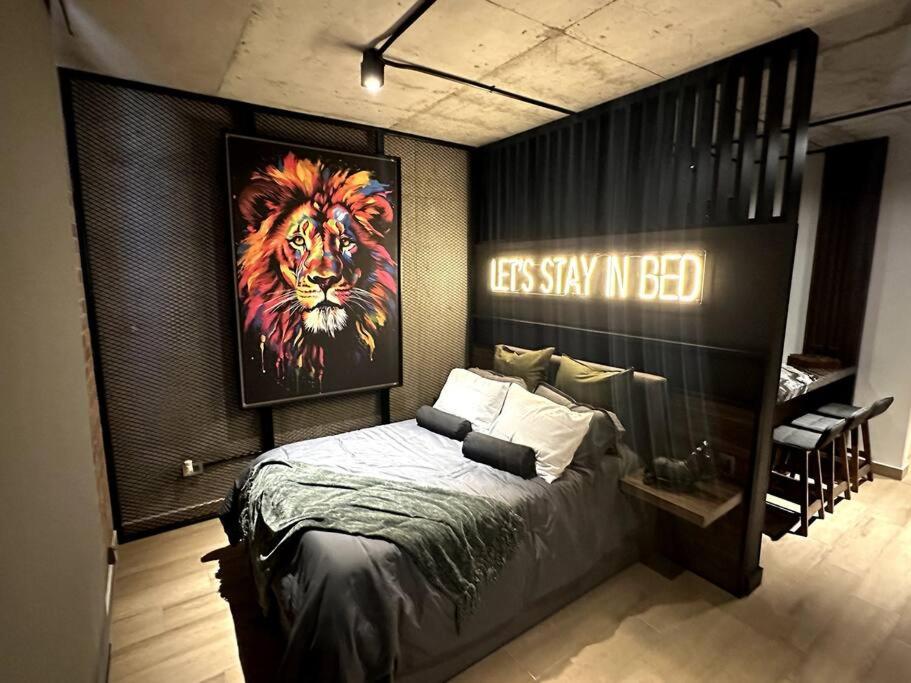 een slaapkamer met een bed met een foto van een leeuw bij Premier Monterrey Retreat 2 in Monterrey