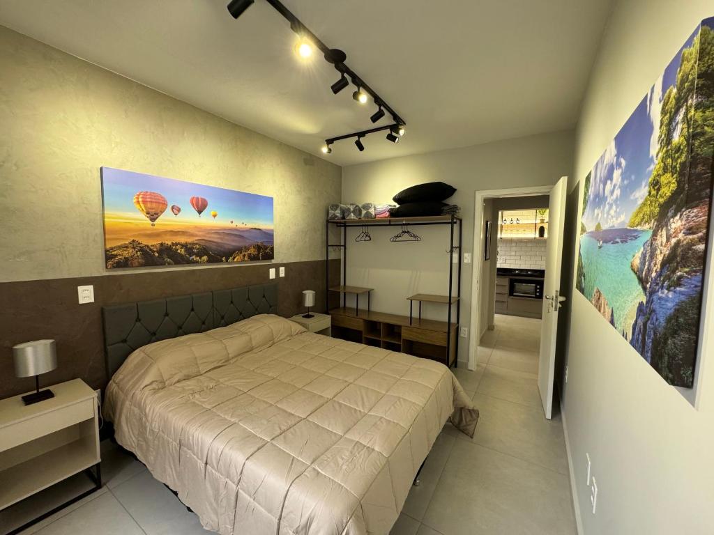 een slaapkamer met een bed en een poster van heteluchtballonnen bij Apartamento Gonzaga Conforto in Santos
