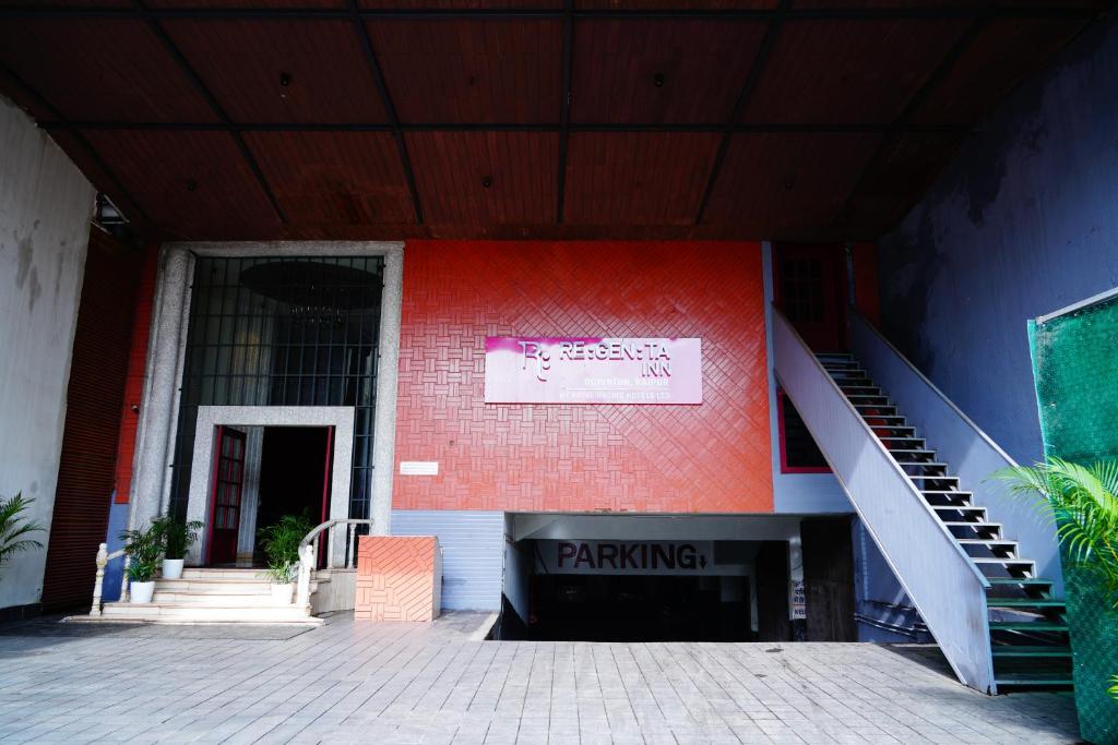 a building with a red wall and a stair case at Regenta Inn Downton Raipur in Raipur