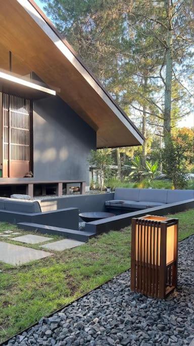a building with benches and a trash can in front of it at Addostays - Mori Machiya in Bandung