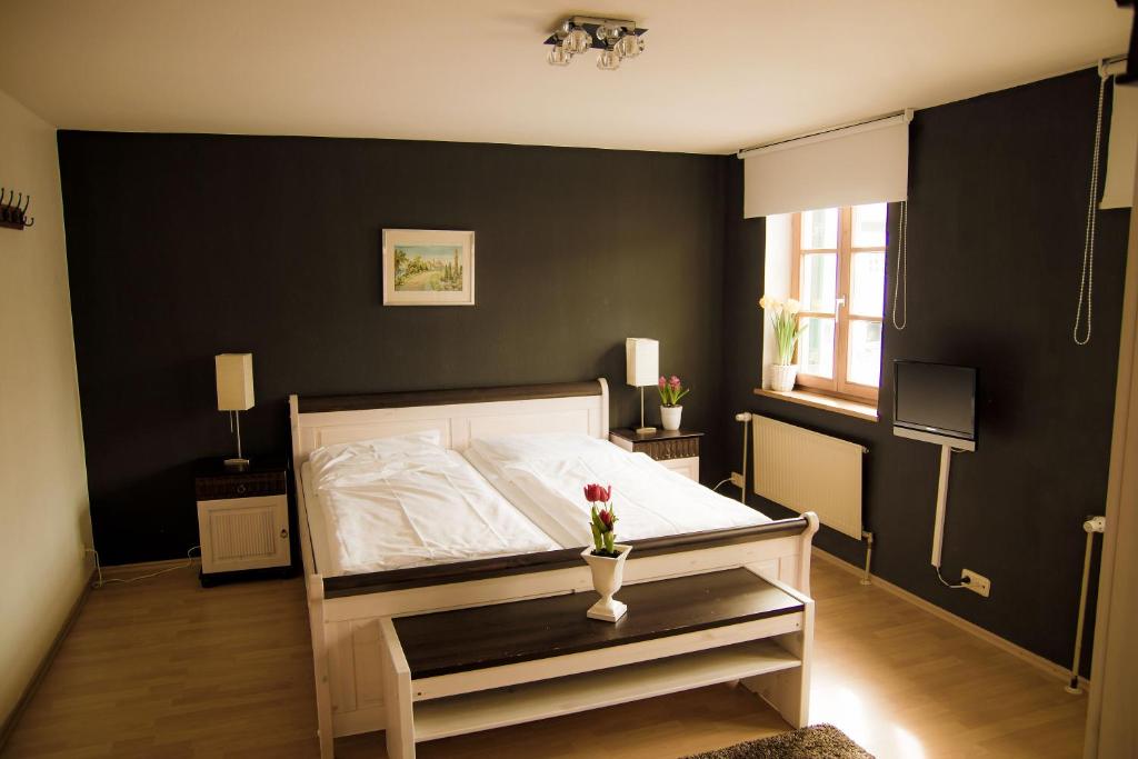 ein Schlafzimmer mit einem weißen Bett und einer schwarzen Wand in der Unterkunft Gasthof Rabenwirt in Pullach im Isartal