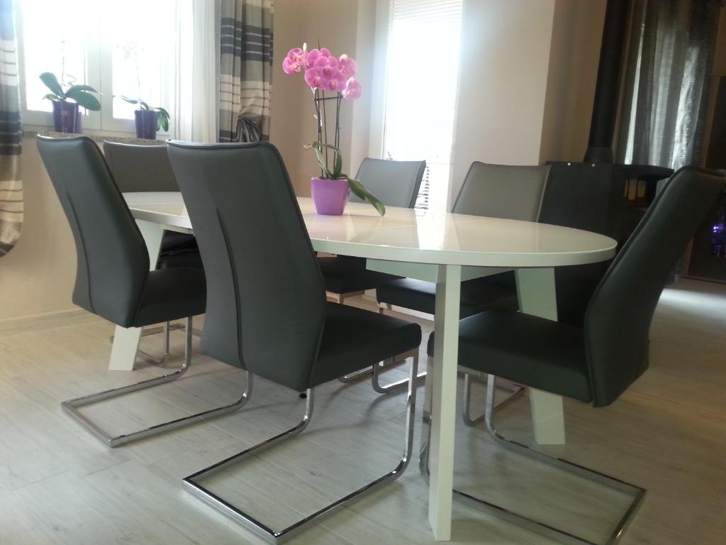 a table and chairs with a white table and flowers at Apartments Roncevic in Zadar