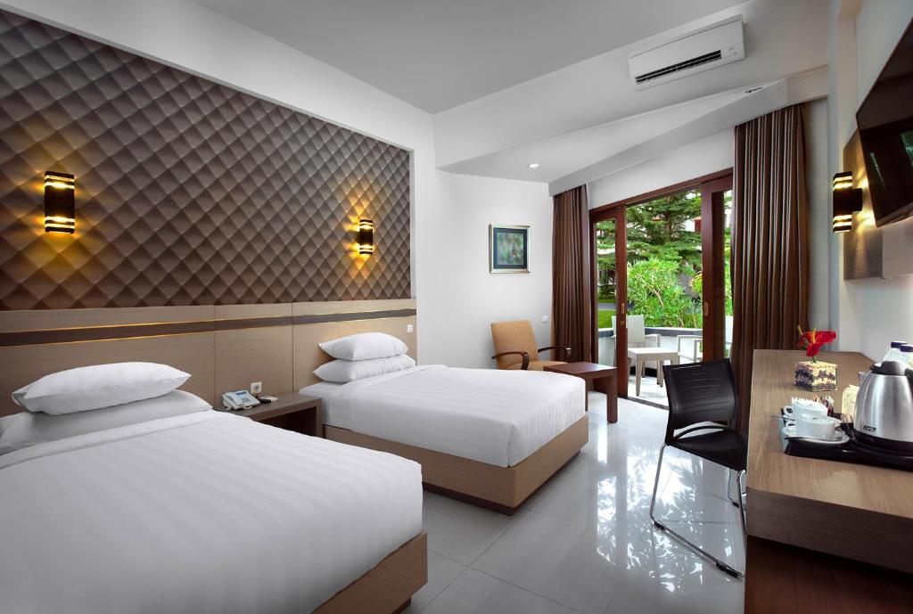 Postel nebo postele na pokoji v ubytování Lombok Raya Hotel
