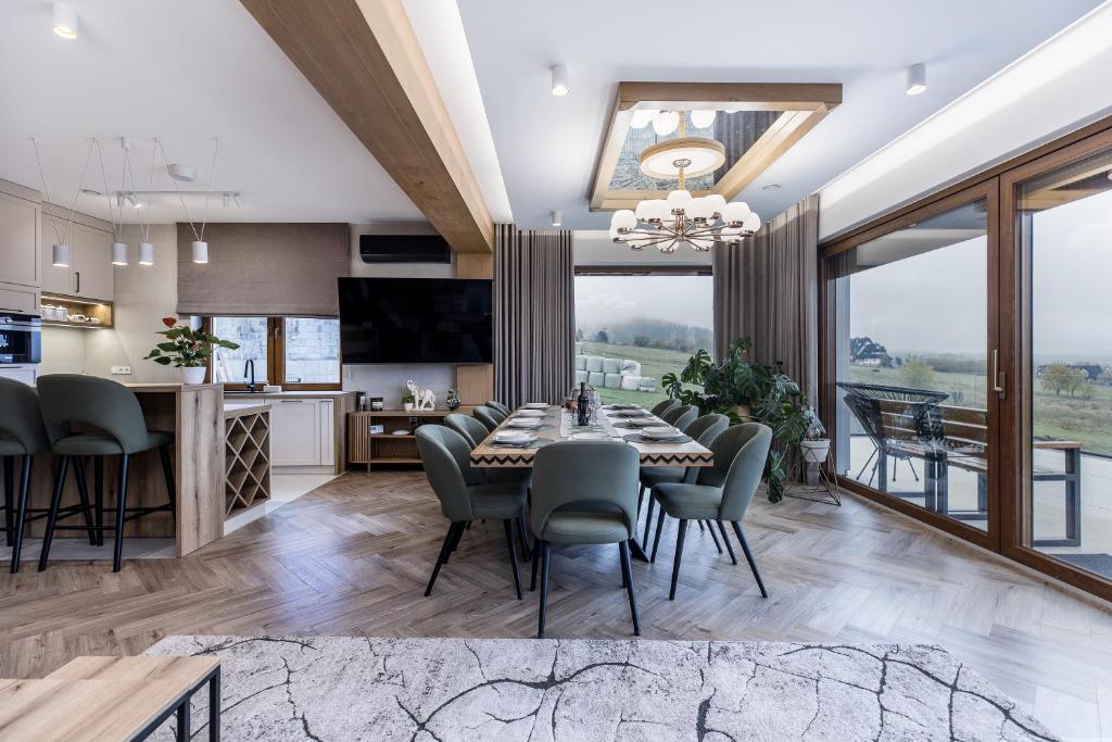 a dining room and kitchen with a table and chairs at Villa Lawendowy Prestige- balia, sauna, bilard in Czarna Góra