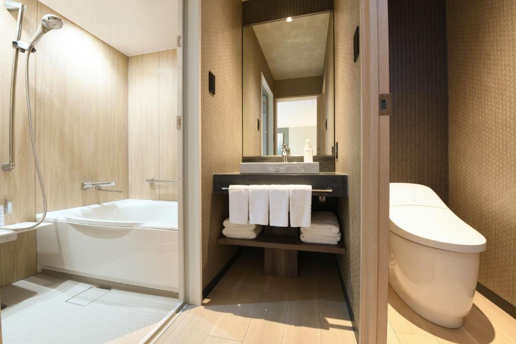 a bathroom with a tub and a sink and a toilet at HOTEL MYSTAYS Ochanomizu Conference Center in Tokyo