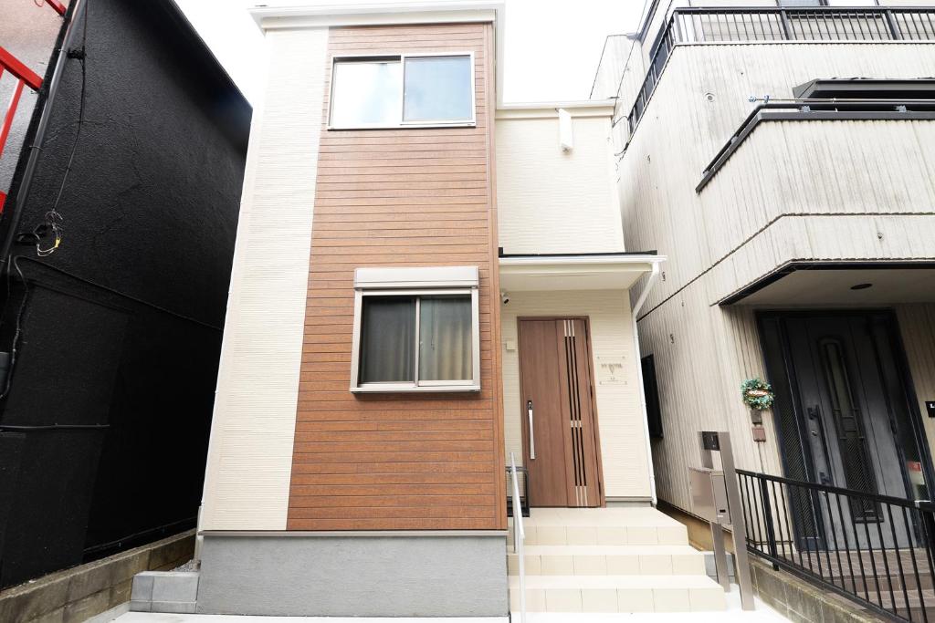 a brick building with a door and a window at NYHotel 5 新宿2階建て4室1バスルーム1シャワー2トイレ in Tokyo