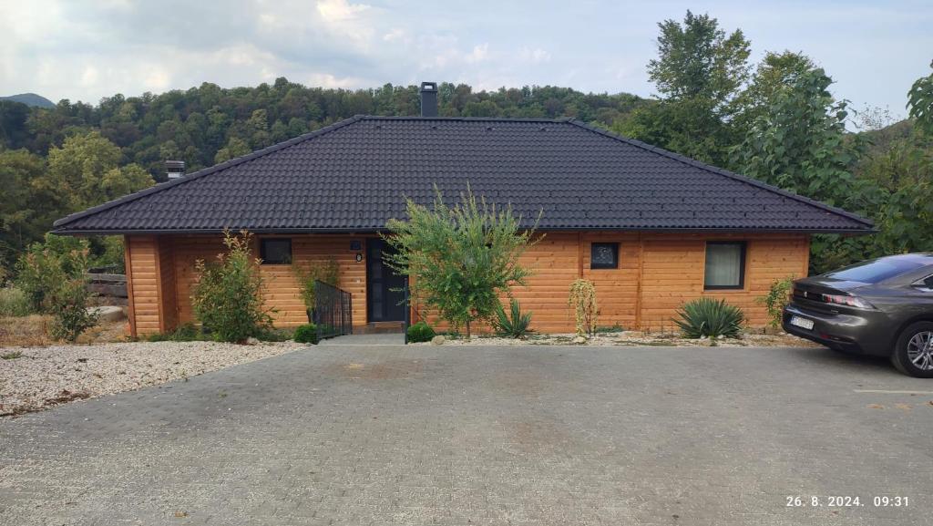 a wooden house with a car parked in front of it at Laganini Country in Samobor