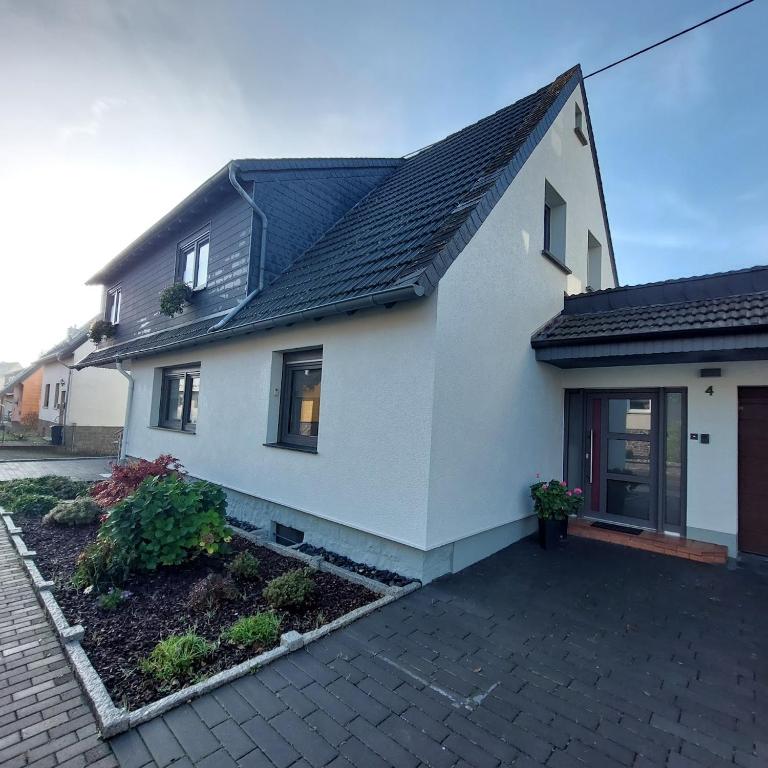 a white house with a black roof at Ferienwohnung Schneider in Baumholder