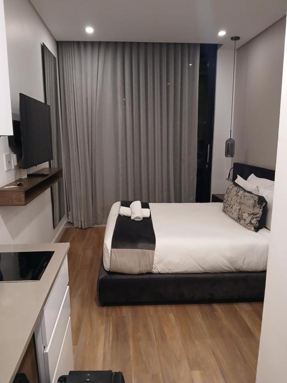 una habitación de hotel con una cama y un televisor en Ikhayalet cape town Central, en Ciudad del Cabo