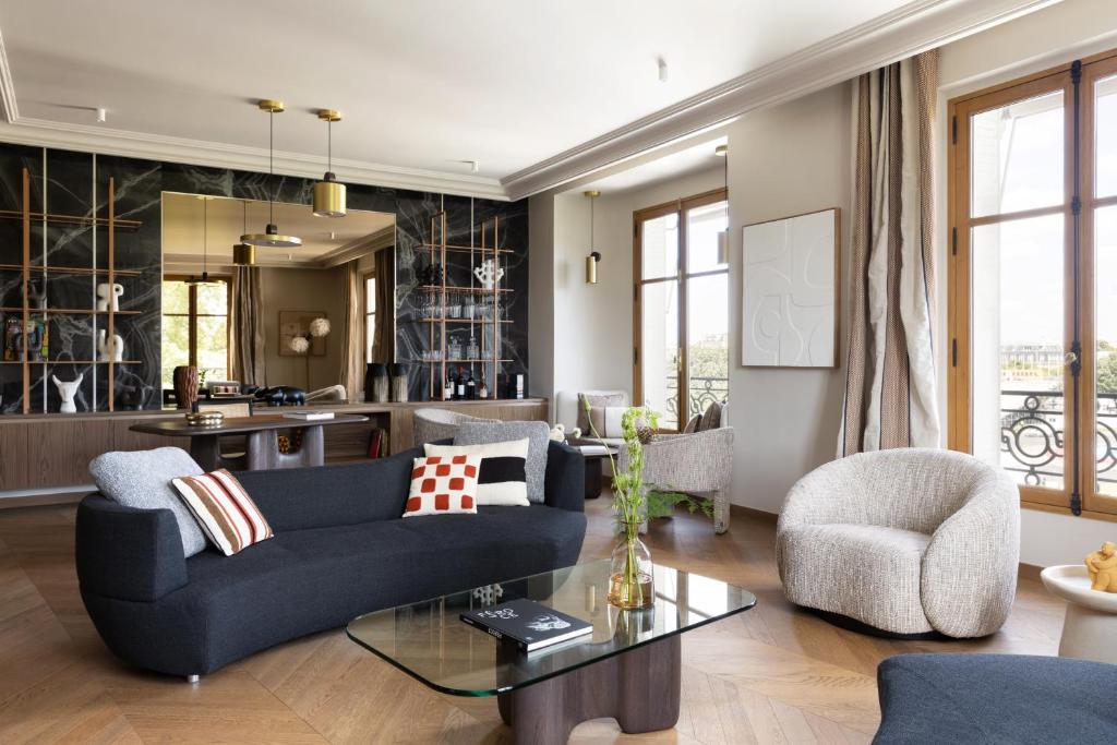 un salon avec un canapé bleu et des chaises dans l'établissement HIGHSTAY - Luxury Serviced Apartments - Invalides, à Paris