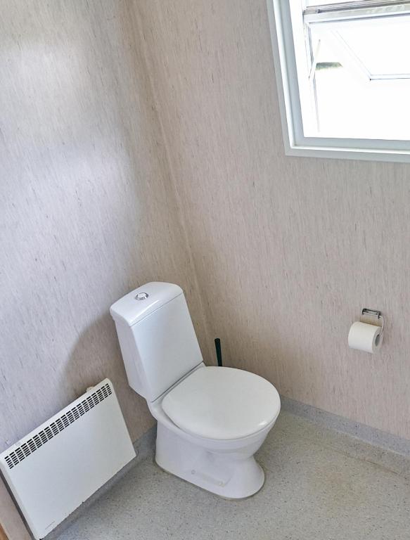 a bathroom with a white toilet and a window at Stevns Camp in Strøby