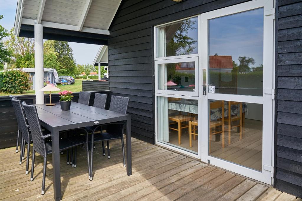 a patio with a table and chairs on a deck at Stevns Camp in Strøby
