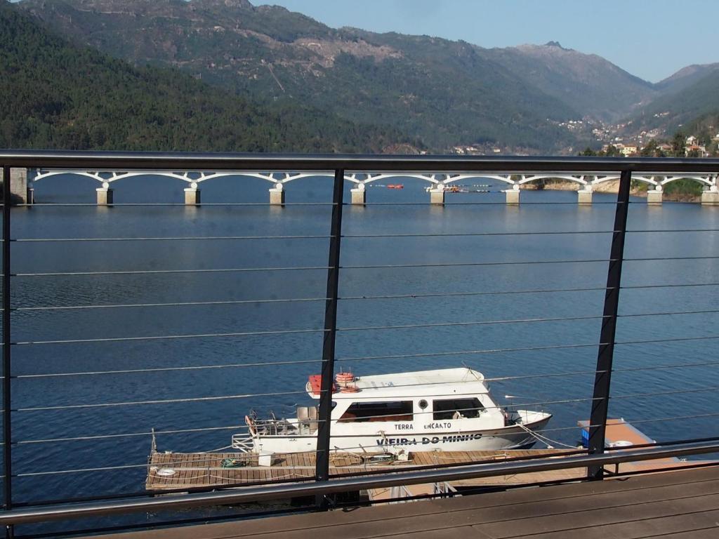 a boat on the water near a bridge at Ancoradouro T1 - Alojamento Local Gerês in Braga