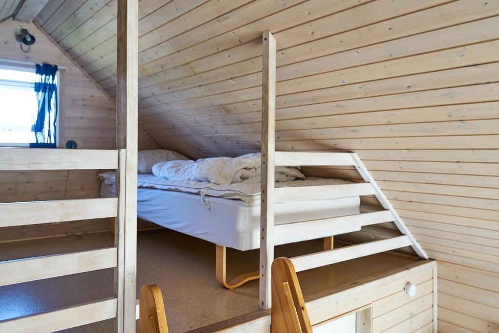 a small room with a bunk bed and a ladder at Stevns Camp in Strøby