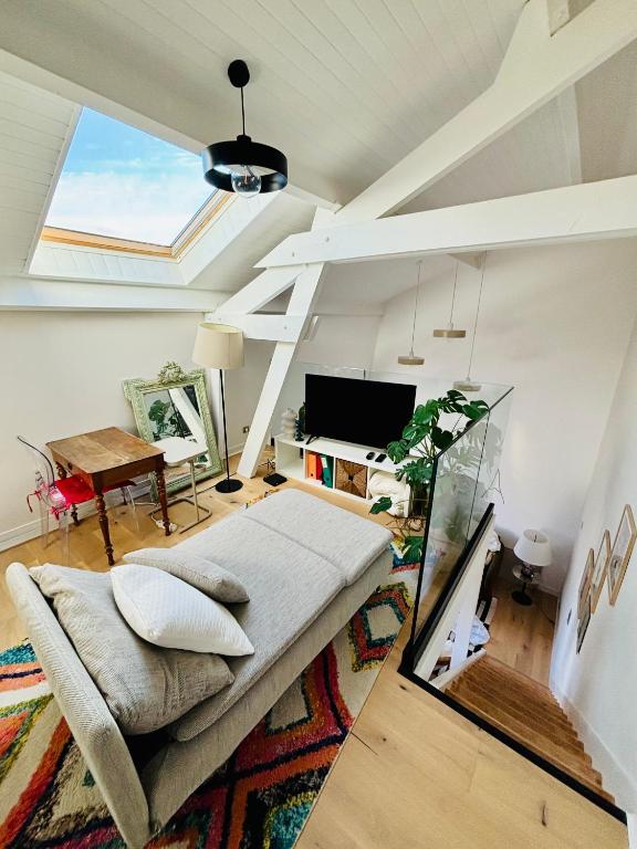 un salon avec un canapé et une télévision dans l'établissement LOFT DE JULIETTE à Saint-Malo, à Saint-Malo