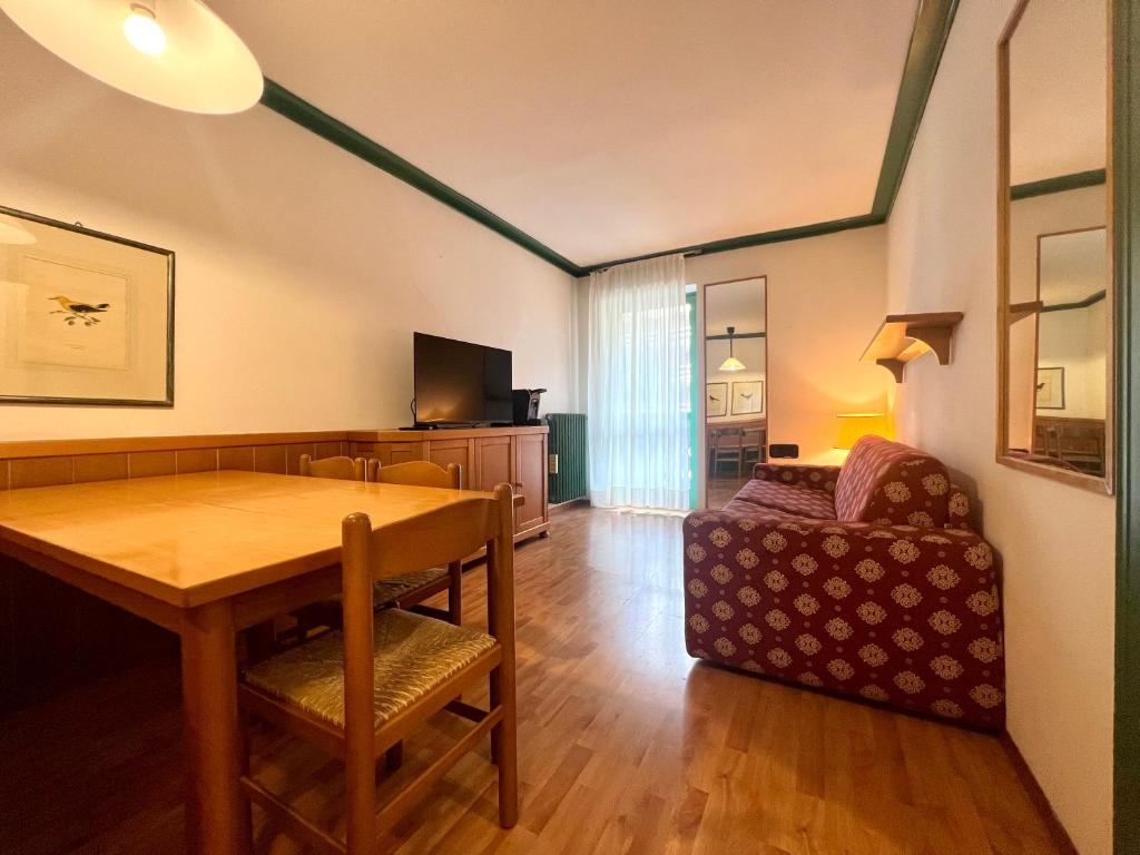 un soggiorno con un tavolo di legno e un divano di Trilocale Sport Campiglio 403 a Madonna di Campiglio